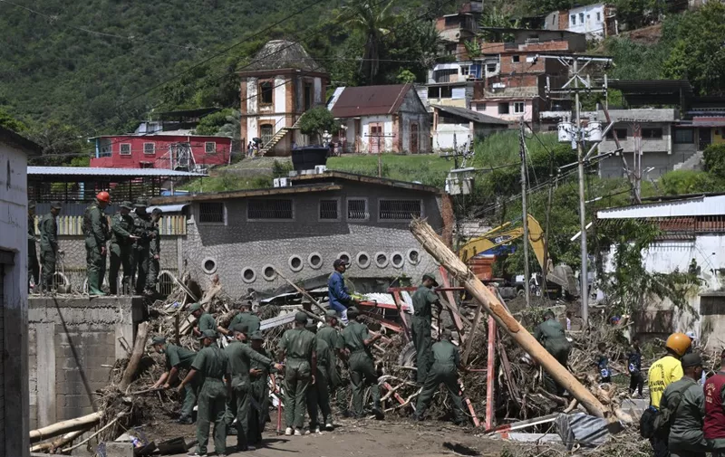 Members of the Venezuelan Army search through the rubble of destroyed houses for victims or survivors after a landslide during heavy rains in Las Tejerias, Aragua state, Venezuela, on October 10, 2022. - A landslide in central Venezuela left at least 22 people dead and more than 50 missing after heavy rains caused a river to overflow, Vice President Delcy Rodriguez said Sunday. (Photo by Yuri CORTEZ / AFP)