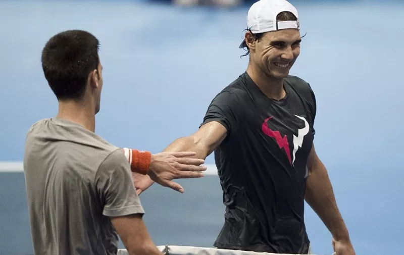 Serbia's Novak Djokovic (L) and Spain's Rafael Nadal meet at the net at the end of their training session ahead of an exhibition tennis match at the Hua Mark indoor stadium in Bangkok on October 2, 2015.      AFP PHOTO / Nicolas ASFOURI