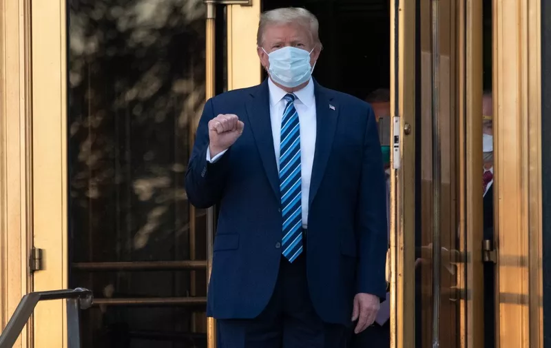 US President Donald Trump walks out of Walter Reed Medical Center in Bethesda, Maryland before heading to Marine One on October 5, 2020, to return to the White House after being discharged. - Trump announced he would be "back on the campaign trail soon", just before returning to the White House from a hospital where he was being treated for Covid-19. (Photo by SAUL LOEB / AFP)