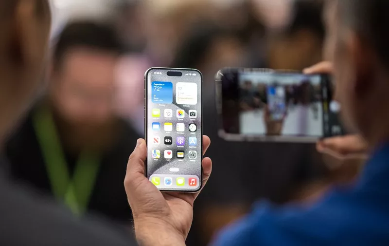 A person looks at an Apple iPhone 15 Pro during a launch event at Apple Park in Cupertino, California, on September 12, 2023. (Photo by Nic Coury / AFP)