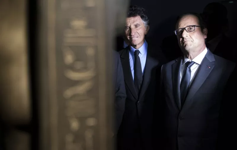 French President Francois Hollande (R) and the president of the World Arabic Institute Jack Lang (L) inaugurate the 'Osiris, Egypt's Sunken Mysteries' exhibition at the Arabic World Institute in Paris on September 7, 2015.  AFP PHOTO / POOL / YOAN VALAT