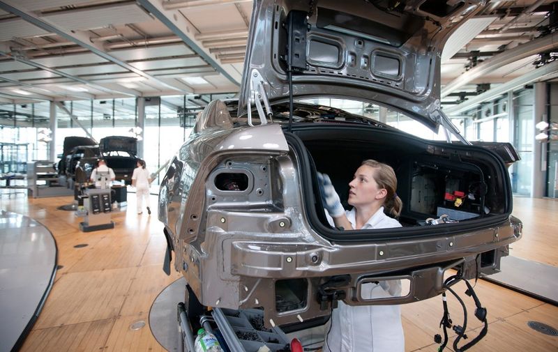 An employee of German car maker Volkswagen (VW) works on a VW Phaeton car at the company's so-called transparent factory (Glaeserne Manufaktur) in Dresden, eastern Germany, on July 30, 2010. Visitors can see at the factory how Volkswagen's premium class model Phaeton is being assembled.    AFP PHOTO    OLIVER KILLLIG    GERMANY OUT (Photo by OLIVER KILLIG / DPA / AFP)