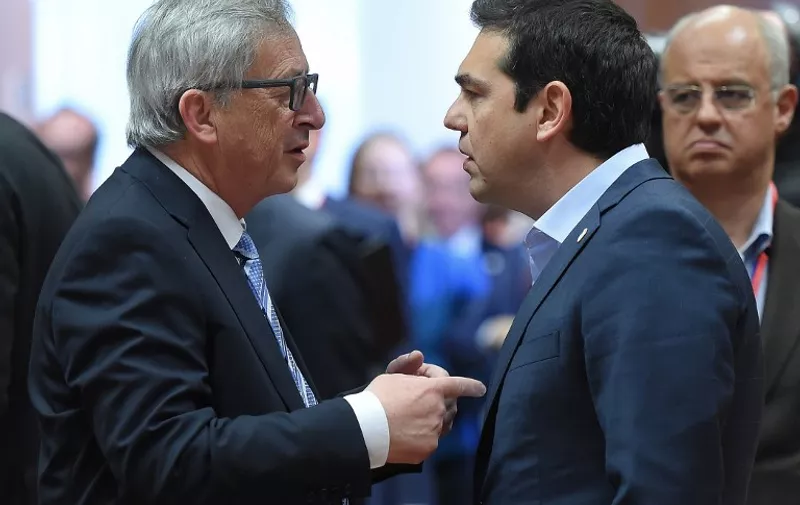European Commission President Jean-Claude Juncker (L) speaks with Greek Prime Minister Alexis Tsipras as they take part in an emergency meeting to discuss Europe's response to the Mediterranean migrants crisis at the European Council in Brussels, April 23, 2015. AFP PHOTO/EMMANUEL DUNAND
