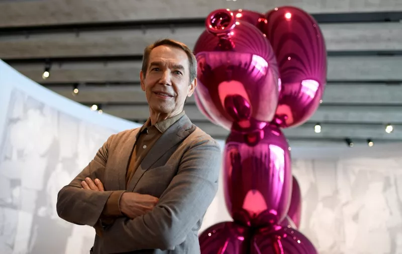 US artist Jeff Koons poses in front of his artwork titled "Balloon dog" displayed at the Museum of European and Mediterranean Civilisations (MuCEM) in Marseille, southern France, on June 28, 2021. - An exhibition showing Koons' art pieces from the Pinault collection runs until October 18, 2021 at the MUCEM. (Photo by Nicolas TUCAT / AFP)