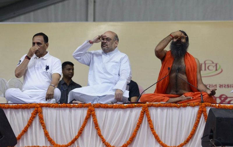 Indian yoga guru Baba Ramdevji (R), Bharatiya Janata Party (BJP) president Amit Shah (C), and Gujarat Chief Minister Vijaybhai Rupani (L) and take part in a massive yoga workshop on International Yoga Day in Ahmedabad on June 21, 2017.
Yoga has connected the world with India, Prime Minister Narendra Modi said June 21 as he rolled his mat along with millions of others across the globe to celebrate the traditional practice.
 / AFP PHOTO / SAM PANTHAKY