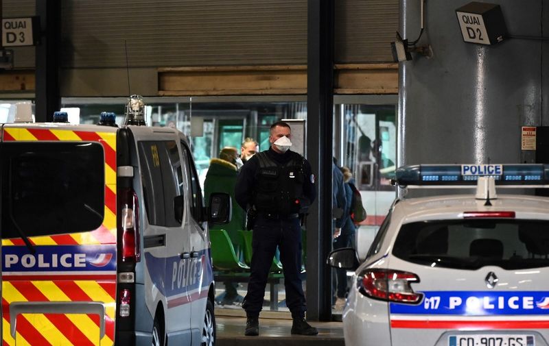 A police officer stands guard at the train and bus station  Lyon Perrache after marking a security zone, following the blockage of a bus coming from Milan due to suspected COVID-19 the novel coronavirus on board, in Lyon, on February 24, 2020. (Photo by JEAN-PHILIPPE KSIAZEK / AFP)