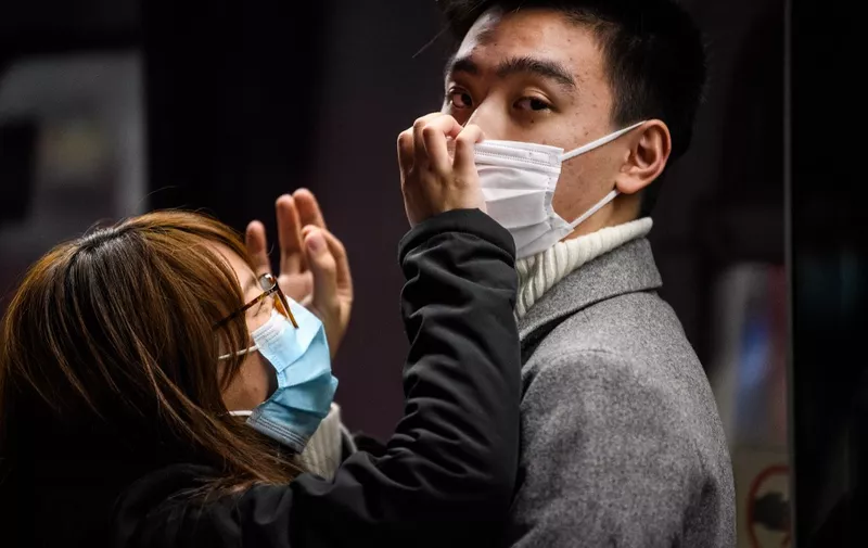 A couple wearing face masks wait on a MTR underground metro train platform during a Lunar New Year of the Rat public holiday in Hong Kong on January 27, 2020, as a preventative measure following a coronavirus outbreak which began in the Chinese city of Wuhan. (Photo by Anthony WALLACE / AFP)
