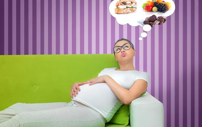 Pregnant woman thinking about food. Hungry expectant mother lying on the couch.