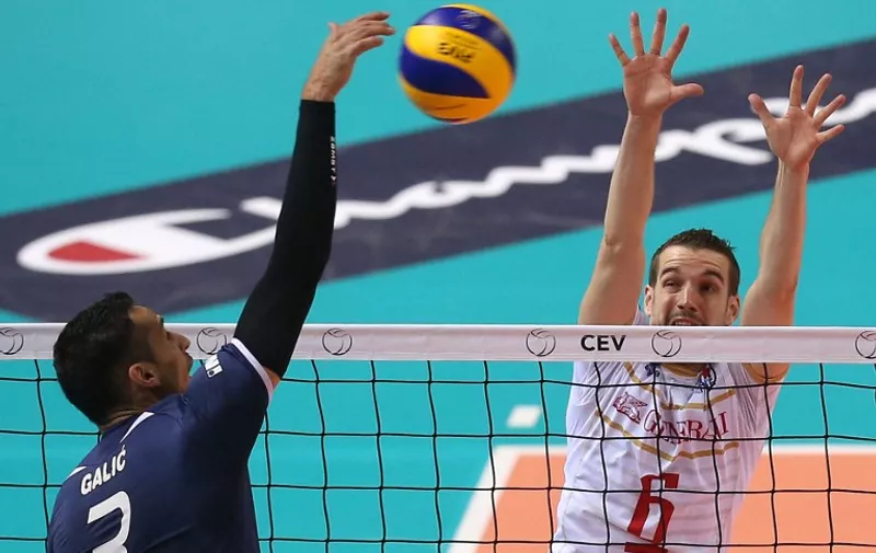 France's Benjamin Toniutti split-block a ball spiked by Croatia's Danijel Galic (L) during the Pool B match between Croatia and France at the European Volleyball Championships in Turin on October 9, 2015.  AFP PHOTO / MARCO BERTORELLO