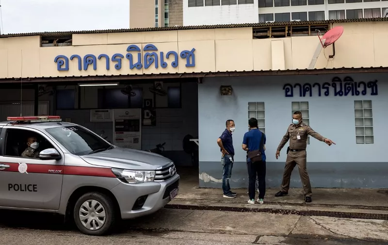 Police officers talk outside the Surat Thani Hospital morgue and forensics lab in southern Thailand's Surat Thani province on March 6, 2022, as Thai authorities prepare to conduct an autopsy on the body of Australian cricket player Shane Warne, who died of a suspected heart attack on March 4 after being found unresponsive in a luxury resort villa on Koh Samui. (Photo by Jack TAYLOR / AFP)