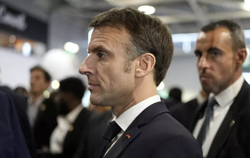French President Emmanuel Macron listens to farmers as he visits on its opening day the 60th International Agriculture Fair (SIA - Salon de l'Agriculture), at the Porte de Versailles exhibition centre in Paris, on February 24, 2024. Macron strolls at the Agricultural Show behind a massive security cordon, but not sheltered from the din of whistles and insults from hundreds of farmers, both ulcerated by his presence and demanding concrete actions to improve their working conditions. (Photo by Lewis Joly / POOL / AFP)