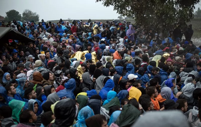 Migrants wait to enter Croatia from the Serbia-Croatia border, near the western Serbian village of Berkasovo, on October 19, 2015. Long lines have formed on Croatia's border with Serbia. Several hundred people remained stuck there on October 19 morning, after having spent the night in rain and cold weather. Earlier on OCtober 18, 2015, migrants were forced to sit for several hours in about 50 buses stuck in Serbia near the border after Croatia stopped allowing any crossings. They later resumed, but at a much slower pace than before. AFP PHOTO / ANDREJ ISAKOVIC