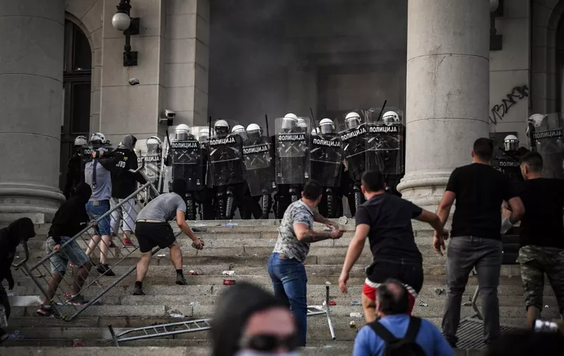 Protesters clash with police in front of Serbia's National Assembly building in Belgrade on July 8, 2020 during a demonstration against a weekend curfew announced to combat a resurgence of COVID-19 infections despite Serbia's president said today it might be scrapped  after the measure sparked the day before angry protests that ended in clashes with police. - Chaotic scenes rocked Belgrade on July 7 at night after thousands of people streamed into the city centre to protest the president's announcement that authorities would reimpose a round-the-clock weekend lockdown. Around 20 people were arrested and dozens were injured in running battles between police, who used tear gas, and protesters who stormed into parliament, threw rocks at officers and were accused of setting police cars alight. (Photo by ANDREJ ISAKOVIC / AFP)