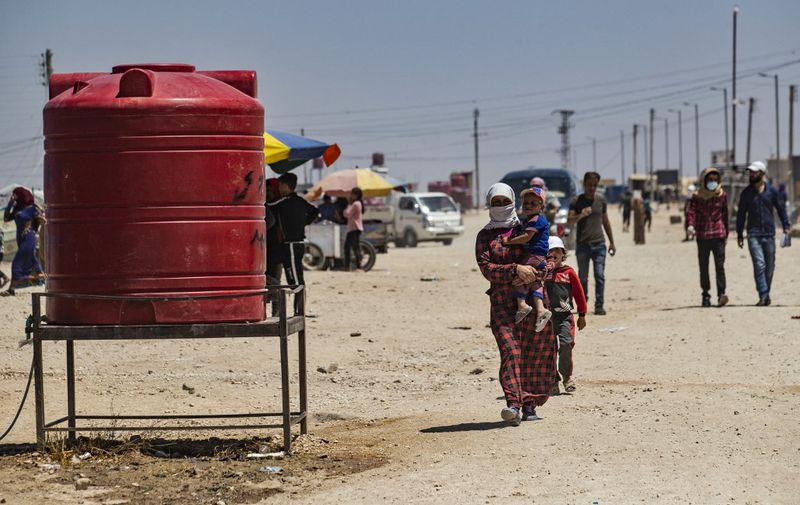 Syrians, displaced from Ras al-Ain, a border town controlled by Turkey and its Syrian proxies, are pictured in the camp of Washukanni in the northeastern Syrian al-Hasakeh governorate, as temperatures soar on June 28, 2021. (Photo by Delil SOULEIMAN / AFP)