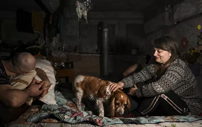 Local residents rest in a basement shelter where they take shelter and live in the village of Chasiv Yar, near the city of Bakhmut in the region of Donbas on March 5, 2023, amid the Russian invasion of Ukraine. (Photo by Aris Messinis / AFP)