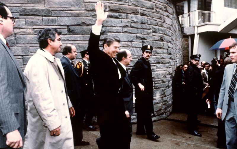 This photo taken by presidential photographer Mike Evens on March 30, 1981 shows President Ronald Reagan waving to the crowd just before the assassination attempt on him, after a conference outside the Hilton Hotel in Washington, D.C.. Reagan was hit by one of six shots fired by John Hinckley, who also seriously injured press secretary James Brady (just behind the car).  Reagan was hit in the chest and was hospitalized for 12 days. Hinckley was aquitted 21 June 1982 after a jury found him mentally unstable.