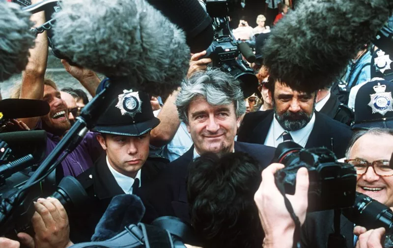 Radovan Karadzic, Bosnian Serb warlord and leader of the Serb-run part of Bosnia during the 1992-1995 war, is mobbed by newsmen on August 26, 1992 as he leaves the London Conference on Yugoslavia. / AFP PHOTO / THIERRY SALIOU