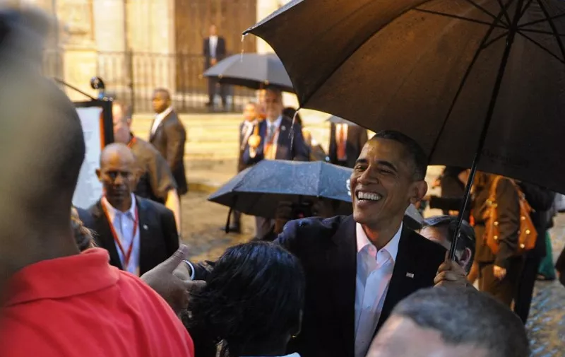 US President Barack Obama talks to tourists and Cubans at his arrival to the Havana Cathedral, on March 20, 2016.  On Sunday, Obama became the first US president in 88 years to visit Cuba, touching down in Havana for a landmark trip aimed at ending decades of Cold War animosity.   AFP PHOTO/YAMIL LAGE / AFP PHOTO / YAMIL LAGE
