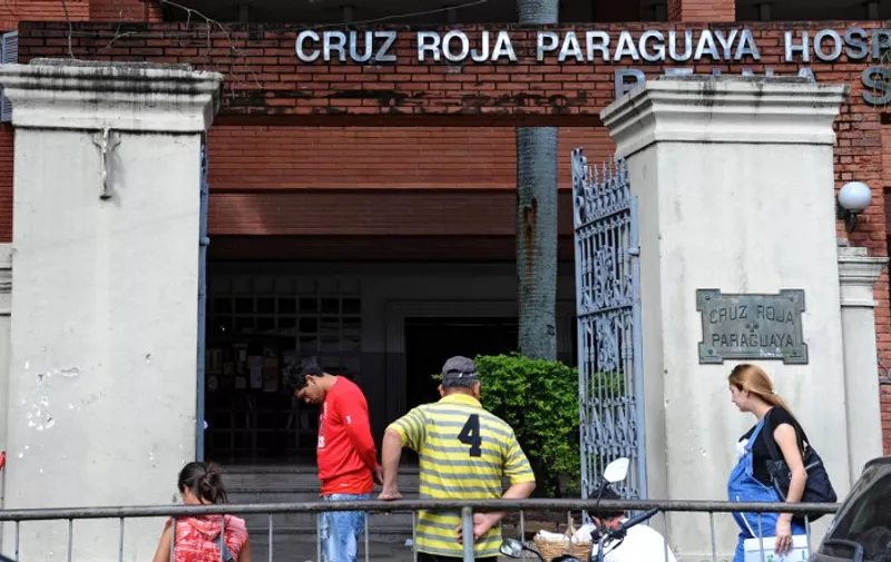 People remain at the entrance of the Red Cross Hospital where a 10-year-old girl who was raped by her stepfather and is now five months pregnant is assited in Asuncion on May 8, 2015. The case has become the focal point of a wrenching debate over abortion and child abuse in this conservative Catholic country. AFP PHOTO / Norberto Duarte