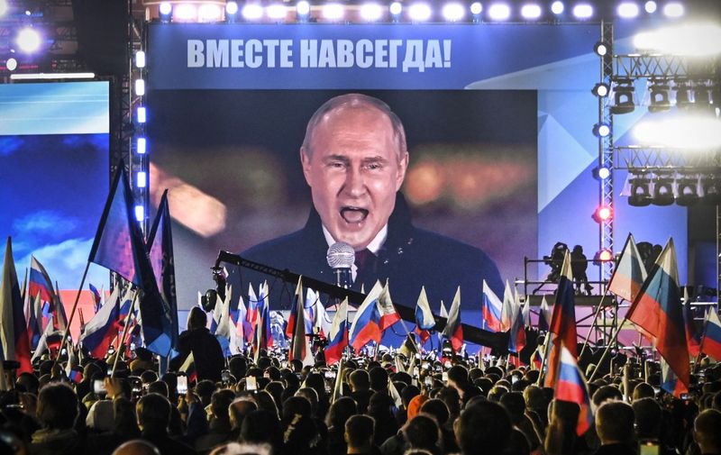 Russian President Vladimir Putin is seen on a screen set at Red Square as he addresses a rally and a concert marking the annexation of four regions of Ukraine Russian troops occupy - Lugansk, Donetsk, Kherson and Zaporizhzhia, in central Moscow on September 30, 2022. (Photo by Alexander NEMENOV / AFP)