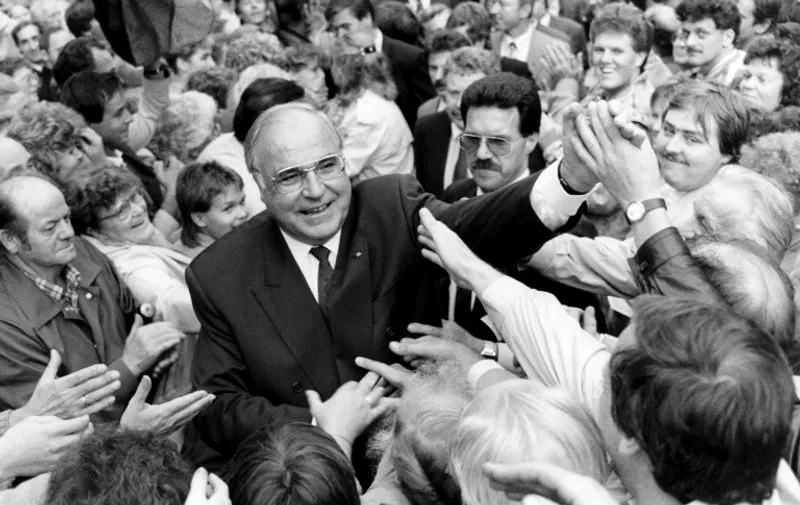 (FILES) This file photo taken on September 4, 1990 shows German Chancellor Helmut Kohl cheered by the crowd of thousands of East Germans who gathered at the Peace Square for the first election rally for the upcoming East German State elections.    
Former German chancellor Helmut Kohl, a colossus of contemporary European history who was celebrated as the father of German reunification and an architect of European integration, died on June 16, 2017 at the age of 87, Bild daily reported. / AFP PHOTO / DPA / MARK-OLIVIER MULTHAUP / Germany OUT