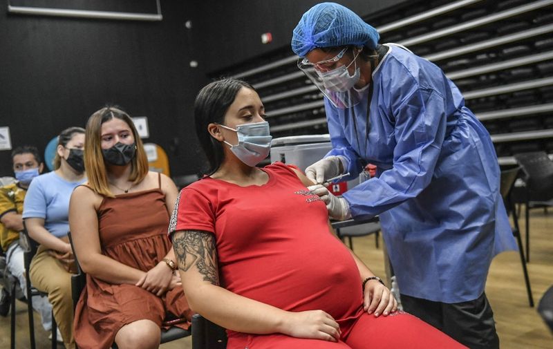 A pregnant woman is inoculated with the Pfizer-BioNTech vaccine against COVID-19 at a vaccination center in Medellin, Colombia on July 24, 2021. - Colombia started to inoculate pregnant women who have three months of pregnancy or more. (Photo by JOAQUIN SARMIENTO / AFP)