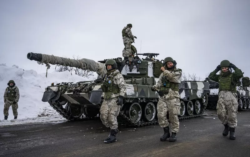 Finnish soldiers of the Finnish-Swedish Devision walk next to the Leopard 2A6, a third generation German main battle tank, after a demonstration of border crossing by Swedish and Finnish troops on March 9, 2024 in the Finnish side of Kivilompolo border crossing between Finland and Norway, located above the Arctic Circle. Nordic Response 24 is part of the larger NATO exercise Steadfast Defender. The exercise involves air, sea, and land forces, with over 100 fighter jets, 50 ships, and over 20,000 troops practicing defensive manoeuvres in cold and harsh weather conditions. (Photo by Jonathan NACKSTRAND / AFP)
