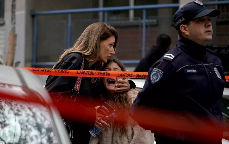 A parent escorts her child following a shooting at a school in the capital Belgrade on May 3, 2023. Serbian police arrested a student following a shooting at an elementary school in the capital Belgrade on May 3, 2023, the interior ministry said. The shooting occurred at 8:40 am local time (06:40 GMT) at an elementary school in Belgrade's downtown Vracar district. (Photo by Oliver Bunic / AFP)