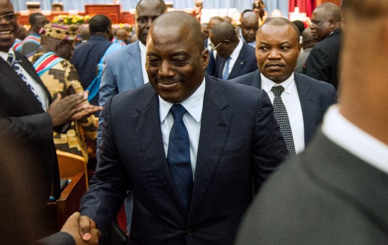 Congolese President Joseph Kabila (C) shakes hands during a special joint session of parliament the day after Prime Minister Augustin Matata resigned to make way for an opposition figure in line with a controversial deal that effectively extends the president's term in office, on November 15, 2016 in Kinshasa. 


The decision to delay presidential polls until at least late 2017 was part of a deal agreed in October by the government and fringe opposition groups that has been boycotted as a sham by the mainstream opposition. / AFP PHOTO / JUNIOR D.KANNAH