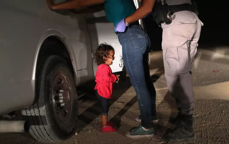 (FILES) In this file photo taken on June 12, 2018 a two-year-old Honduran asylum seeker cries as her mother is searched and detained near the US-Mexico border in McAllen, Texas. - Getty Images photographer John Moore has won the 2019 World Press Photo of the Year award with this photo of the two-year-old Honduran asylum seeker crying as her mother is searched and detained near the US-Mexico border in McAllen. (Photo by JOHN MOORE / GETTY IMAGES NORTH AMERICA / AFP)