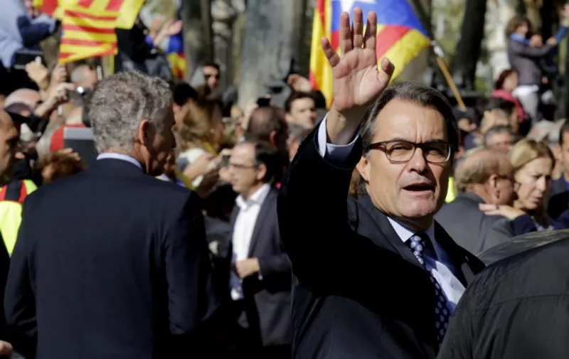 Catalonia's regional government president and leader of the Catalan Democratic Convergence (CDC) Artur Mas, waves as he leaves the TSJC (Superior Court of Catalonia) on October 15, 2015 in Barcelona after going before a judge charged with civil disobedience and misuse of public funds for holding a non-binding ballot in November 2014 in which Catalans were asked to vote on whether their region should remain part of Spain.  Spanish judges earlier this week started questioning Catalan officials charged with breaking the law by holding a vote last year on their contested drive for independence from Spain.  AFP PHOTO / PAU BARRENA