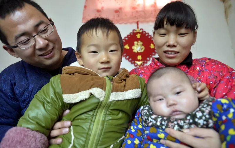 --FILE--A Chinese couple and their two children pose for a photo at home in Daliangzhuang village, Jiazhai town, Chiping county, Liaocheng city, east China's Shandong province, 5 December 2015.

From January 1 all Chinese couples will finally be free from the country's infamous one-child policy, with legislation permitting the birth of a second child set to go into effect with the new year. Xinhua reports that the decision was officially passed on Sunday, during last week's bi-montly session of the National People's Congress Standing Committee. The Communist Party first announced the transformation of legislation in October. Prior to that the move was foreshadowed with a relaxation in policy at the start of last year for parents who were themselves only children. "The state advocates that one couple shall be allowed to have two children," declares the Law on Population and Family Planning, officially now. It marks the end of the notorious one-child policy era that began in the 1970s to control population growth. Also now banished, we presume, are the heavy fines, forced abortions and sterilizations. Some critics, however, remain unconvinced by the recent move. "Couples that have two children could still be subjected to coercive and intrusive forms of contraception, and even forced abortions -- which amount to torture," researcher William Nee remarked. "The state has no business regulating how many children people have." Prior research also shows a reluctance on the part of Chinese citizens to take advantage of the policy due to the expense of raising more than one child. The one-child policy has wreaked havoc on China's demographics, with some predicting that the country will have the most elderly population in the world within 15 years. (Photo by Zhao yuguo / Imaginechina / Imaginechina via AFP)
