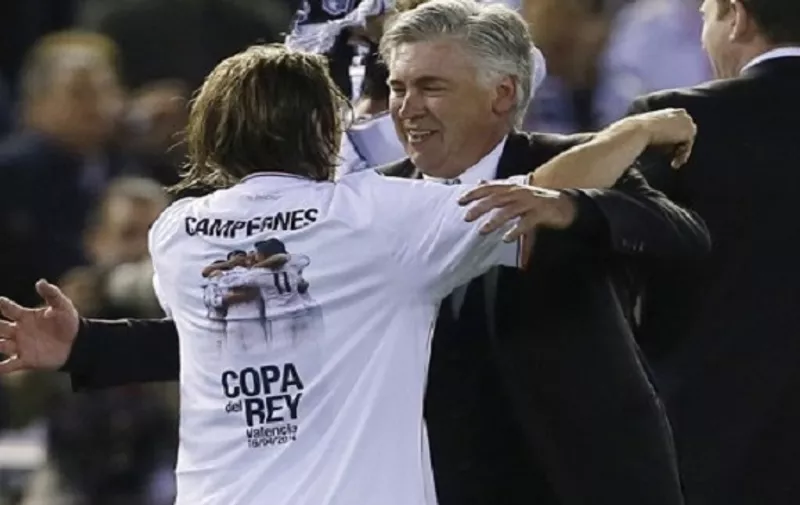 Real Madrid's Italian coach Carlo Ancelotti (R) celebrates with Real Madrid's Croatian midfielder Luka Modric after winning the Spanish Copa del Rey (King's Cup) final "Clasico" football match FC Barcelona vs Real Madrid CF at the Mestalla stadium in Valencia on April 16, 2014. Real Madrid won the match 2-1.  AFP PHOTO / CESAR MANSO