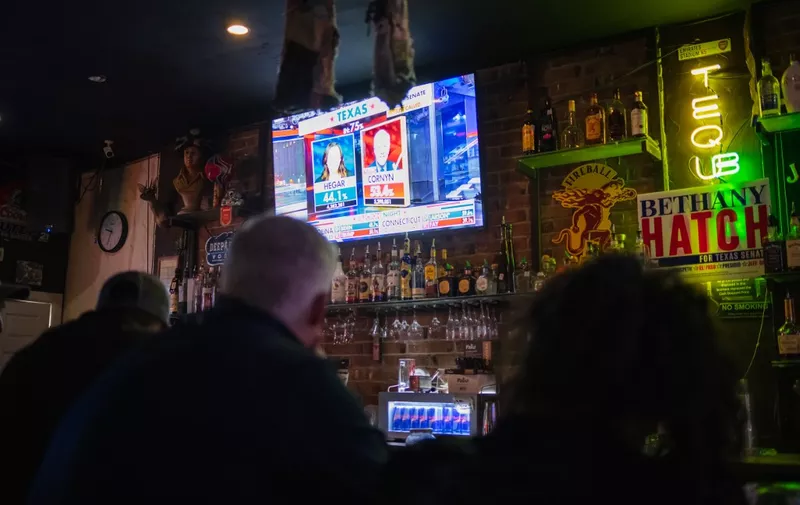 People watch as the election results come in at a pro US President Donald Trump watch party at the Rockin Cigar Bar, in defiance of a county wide shutdown order, in El Paso, Texas on November 3, 2020. (Photo by Justin HAMEL / AFP)