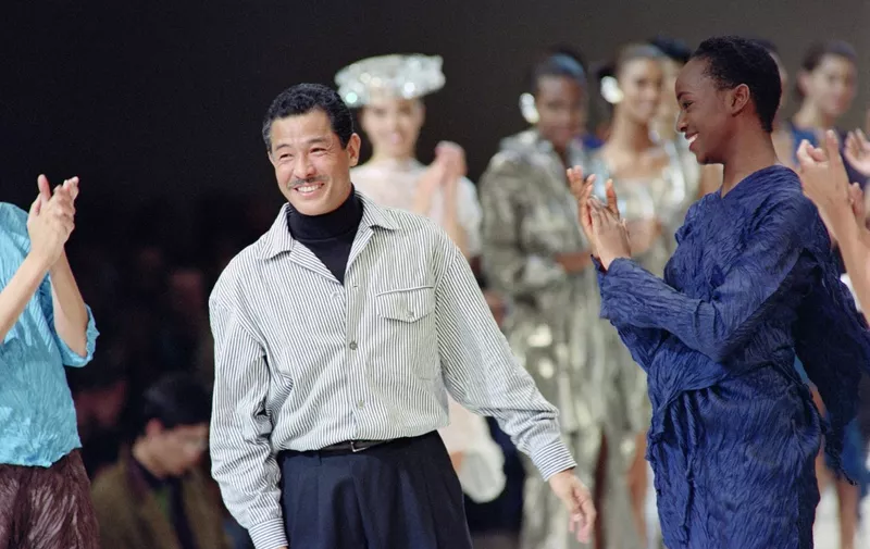 (FILES) This file photo taken on October 19, 1991 shows Japanese fashion designer Issey Miyake acknowledging the applause from models and attendees after presenting his 1992 Spring-Summer collection in Paris. - Japanese fashion designer Issey Miyake, whose global career spanned more than half a century, has died aged 84, an employee at his office in Tokyo told AFP on August 9, 2022. (Photo by Pierre GUILLAUD / AFP)