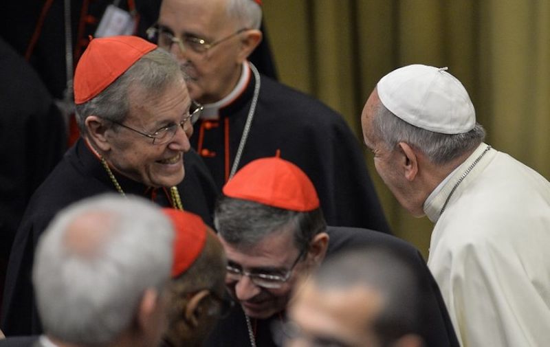 Pope Francis (R) speaks with German Cardinal Walter Casper before  the Synod on the Families, to cardinals and bishops gathering in the Synod Aula, at the Vatican, on October 6, 2014. Pontiff on Sunday launched a major review of Catholic teaching on the family that could lead to change in the Church's attitude to marriage, cohabitation and divorce. An extraordinary synod, or meeting, of nearly 200 bishops from around the world and a sprinkling of lay people will, for the next two weeks, address the huge gulf between what the Church currently says on these issues and what tens of millions of believers actually do.   AFP PHOTO / ANDREAS SOLARO / AFP PHOTO / ANDREAS SOLARO