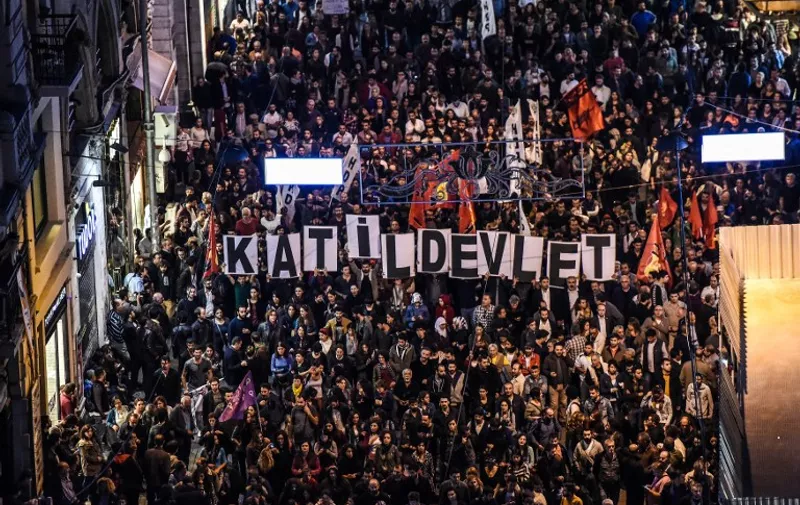 Placards reading "Killer state" are seen as thousands of protesters take part in a march against the deadly attack earlier in Ankara on October 10, 2015 at the Istiklal avenue in Istanbul. At least 86 people were killed on October 10 in the Turkish capital Ankara when bombs set off by two suspected suicide attackers ripped through leftist and pro-Kurdish activists gathering for an anti-government peace rally, the deadliest attack in the history of modern Turkey. AFP PHOTO / OZAN KOSE