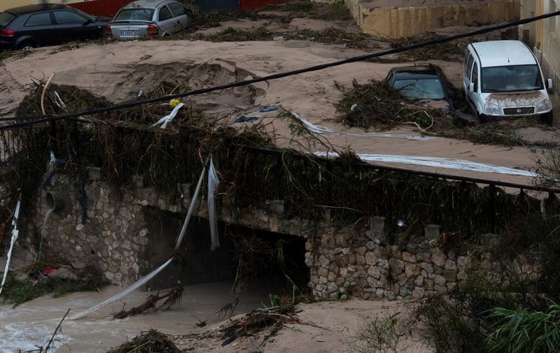 Damaged cars are pictured after a street was flooded in Ontinyent on September 12, 2019 as torrential rains hit southeastern Spain overnight, sparking major flooding in the Valencia region and closing schools in a move affecting a quarter of a million children. (Photo by JOSE JORDAN / AFP)
