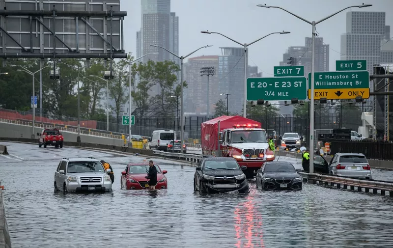 Cars in floodwater on the FDR highway in Manhattan, New York on September 29, 2023. Heavy rains overnight in the northeastern United States left parts of New York City under water on Friday, partially paralyzing subways and airports in the country's financial capital. (Photo by Ed JONES / AFP)