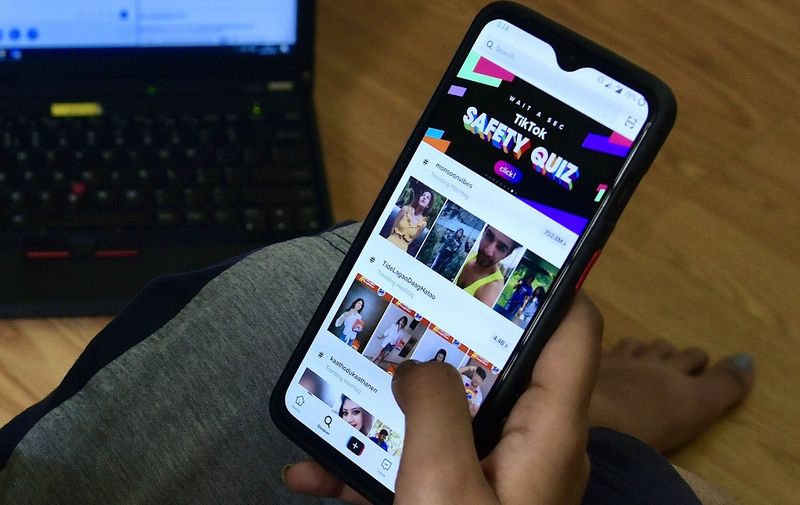 An Indian mobile user browses through the Chinese owned video-sharing 'Tik Tok' app on a smartphone in Bangalore on June 30, 2020. - TikTok on June 30 denied sharing information on Indian users with the Chinese government, after New Delhi banned the wildly popular app citing national security and privacy concerns.
"TikTok continues to comply with all data privacy and security requirements under Indian law and have not shared any information of our users in India with any foreign government, including the Chinese Government," said the company, which is owned by China's ByteDance. (Photo by Manjunath Kiran / AFP)