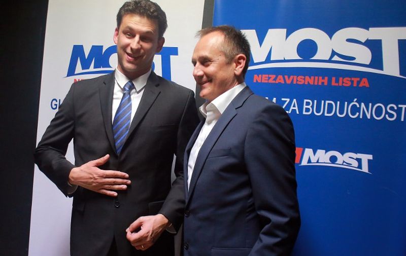 Leaders of the MOST coalition Bozo Petrov (L) and Milan Kujunddic (R) smile after the first exit polls of the general elections in Zagreb, on November 8, 2015.  Croatia goes to the polls to elect a new government at a time when its economy is among the weakest in the European Union.   AFP PHOTO / STRINGER