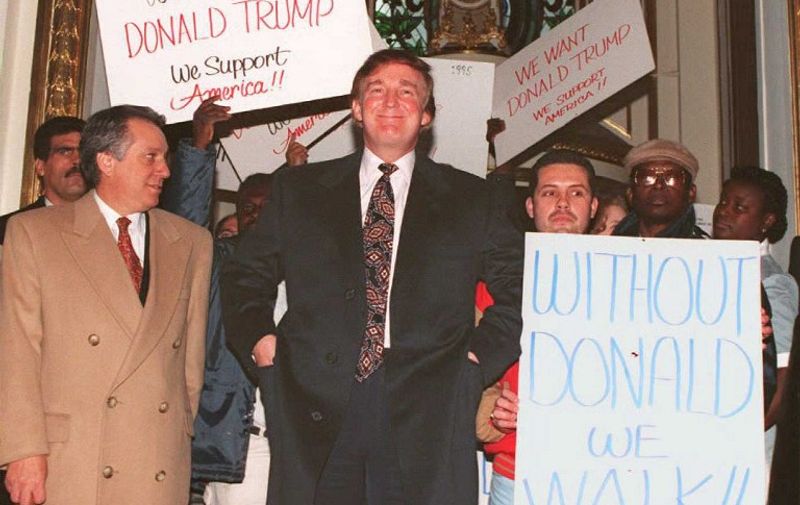 US business tycoon Donald Trump(C) enters the PLaza Hotel in New York past supporters 21 December 1994. Hundreds of supporters showed up at a news conference where Trump denied a New York newspaper report that the Sultan of Brunei had bid 300 million USD to buy the Manhattan hotel.  / AFP PHOTO / DON EMMERT