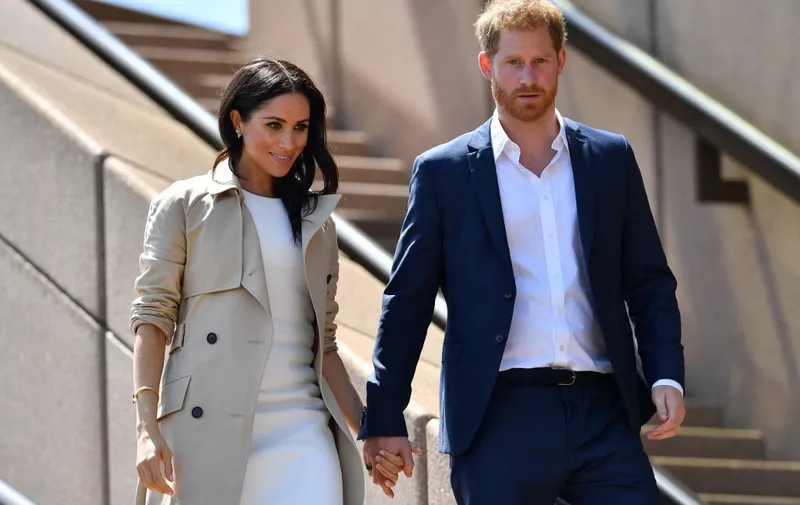 (FILES) In this file photo taken on October 16, 2018 Britain's Prince Harry and his wife Meghan walk down the stairs of Sydneys iconic Opera House to meet people in Sydney. - After a week of digs at Britain's royal family, just how far will Prince Harry and Meghan Markle go in their hotly anticipated interview with Oprah Winfrey? Millions of people will tune in to CBS the evening of March 7, 2021 to find out, and if that trickle of excerpts is any indication, they have scores to settle with Buckingham Palace a bit over a year after giving up frontline duties as royals and moving to southern California. (Photo by SAEED KHAN / AFP)