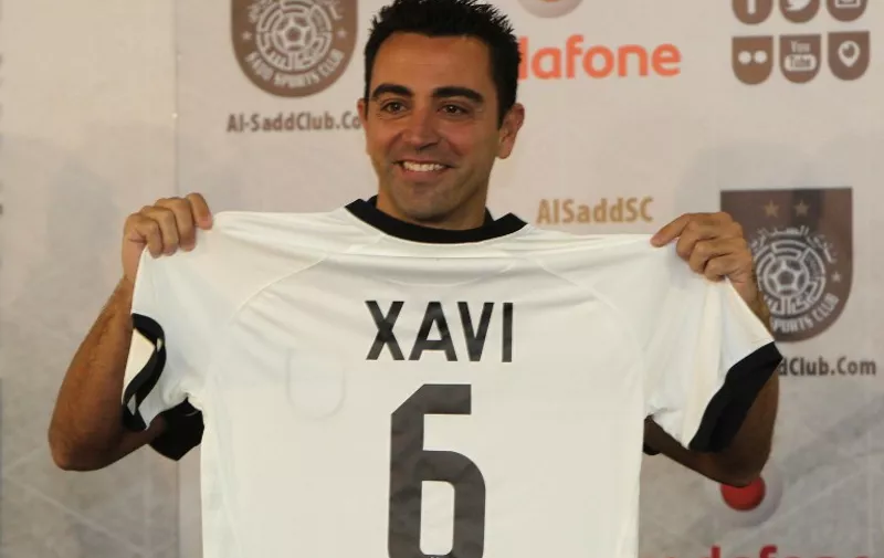 Barcelona legend Xavi Hernandez gestures in his new Al-Sadd club shirt after signing a two-year contract with the Qatari football team in Doha on June 11, 2015. AFP PHOTO / STR