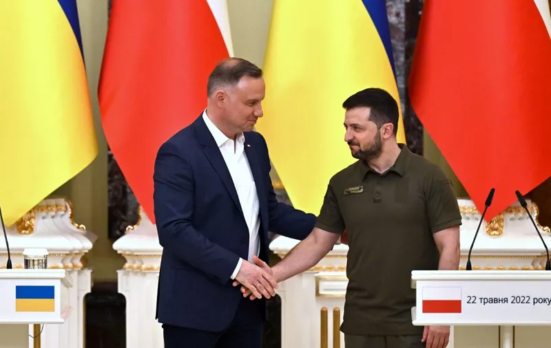 Ukrainian President Volodymyr Zelensky (R) and his Polish counterpart Andrzej Duda shake hands during a press conference following their talks in Kyiv on May 22, 2022, amid Russia's military invasion launched on Ukraine. (Photo by Sergei SUPINSKY / AFP)