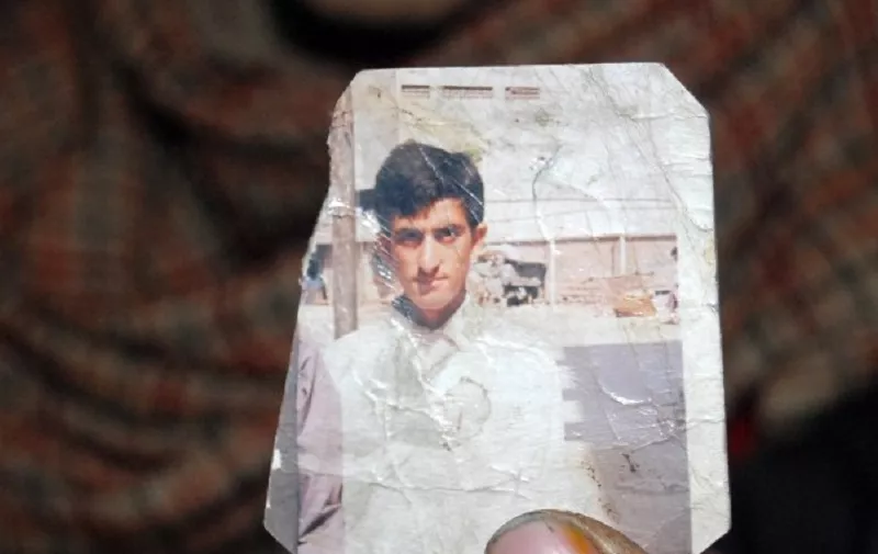 (FILES) This file photograph taken on March 12, 2015, shows one of the Pakistani Kashmir parents of convicted killer Shafqat Hussain holding a photograph of their son in Muzaffarabad, the capital of Pakistani-administered Kashmir.   Pakistan on August 4, 2015, executed a convicted killer whose supporters say was a juvenile at the time of his crime, despite strenuous objections from rights groups and the United Nations.   AFP PHOTO/ SAJJAD QAYYUM / FILES