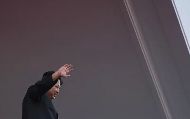North Korea's leader Kim Jong-Un waves from a balcony towards participants of a mass military parade at Kim Il-Sung square in Pyongyang on October 10, 2015. North Korea was marking the 70th anniversary of its ruling Workers' Party. AFP PHOTO / Ed Jones / AFP / ED JONES
