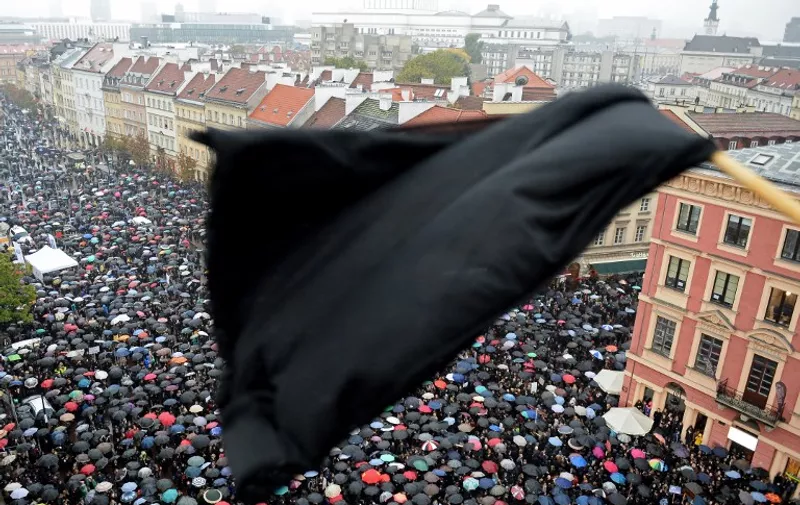A black flag is seen as people take part in a nationwide strike and demonstration to protest against a legislative proposal for a total ban of abortion on October 3, 2016 in Warsaw.
Thousands of women dressed in black protested across Poland in the "Women strike" campaign against a proposed near-total abortion ban in the devoutly Catholic country where legislation is already among the most restrictive in Europe. / AFP PHOTO / JANEK SKARZYNSKI
