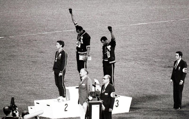 1968 Olympic Games, Mexico City America&#8217;s gold and bronze medallists Tommie Smith (centre) and John Carlos (right) raise their arms as a &#8216;Black Power&#8217; gesture during the Olympic Awards Ceremony. Smith had set a world record of 19.8 seconds in the 200 metre race. Each man wore a black glove on one hand and raised [&hellip;]