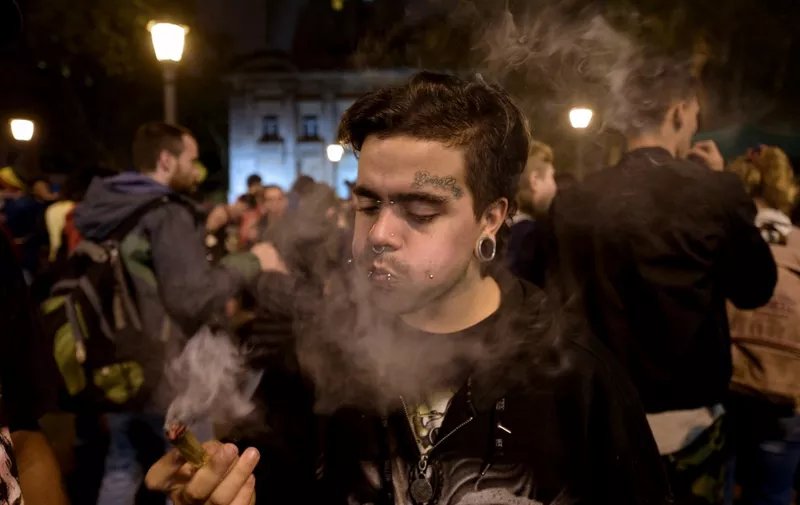 A man smokes marijuana during the Global Marijuana March (GMM) in Montevideo on May 4, 2018. (Photo by MIGUEL ROJO / AFP)